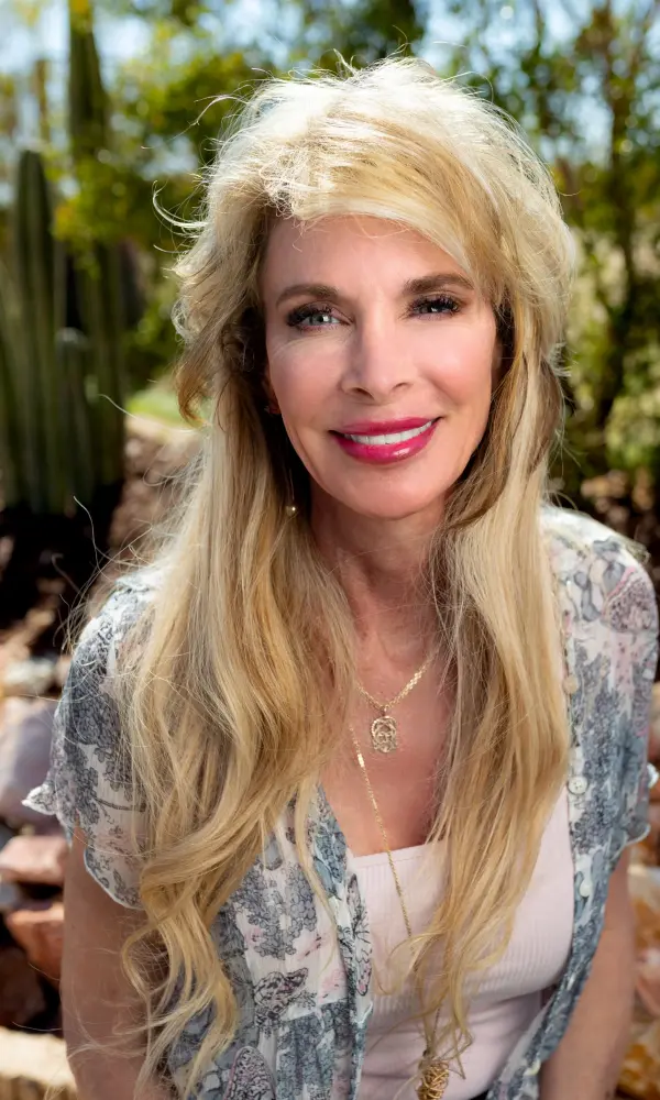 1743246113_CherylPalazzapic Woman smiling outdoors with long blonde hair.