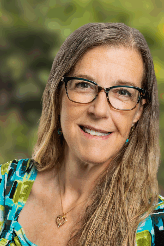 Smiling woman wearing glasses with a natural background.