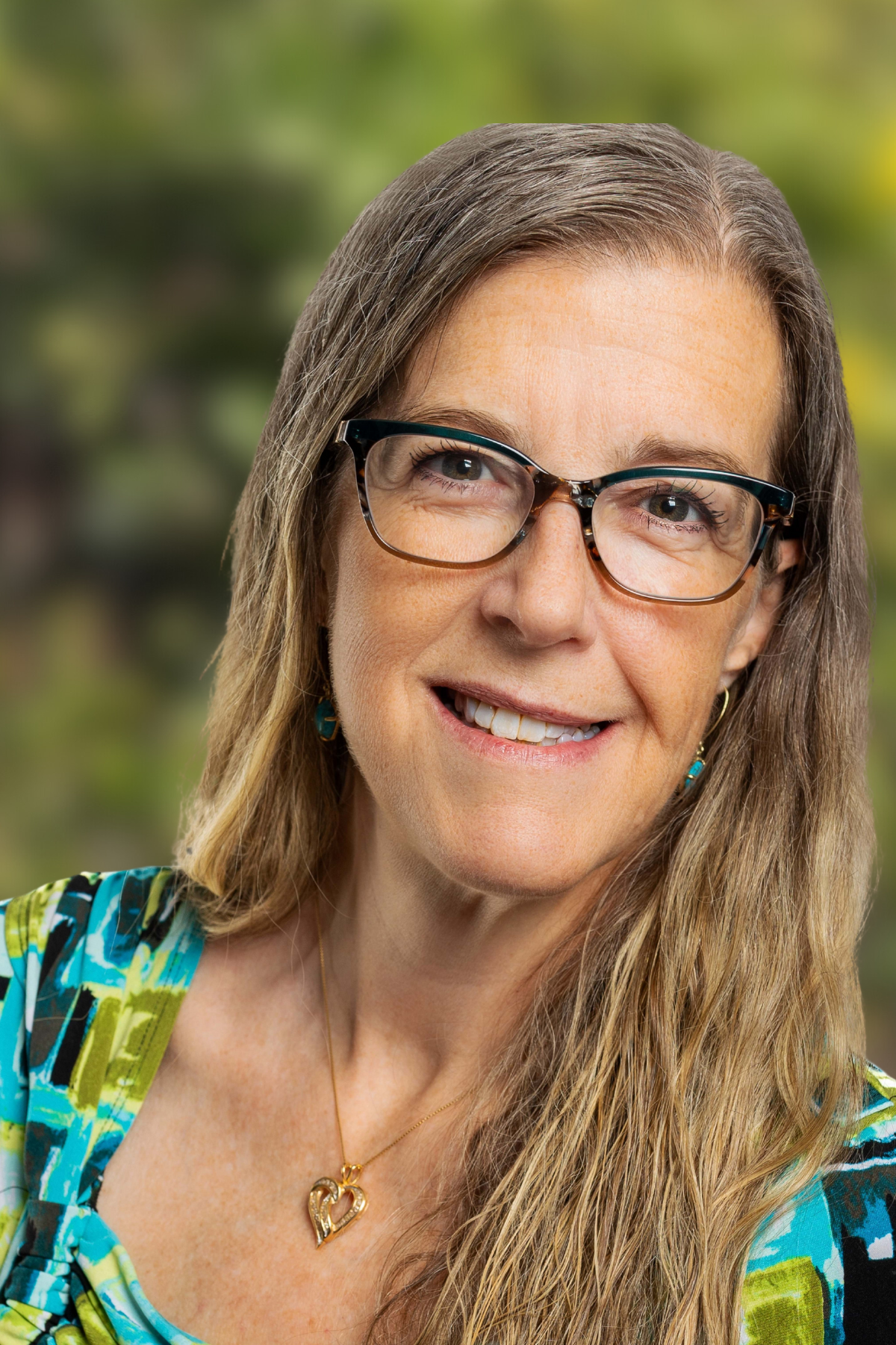 Smiling woman wearing glasses with a natural background.