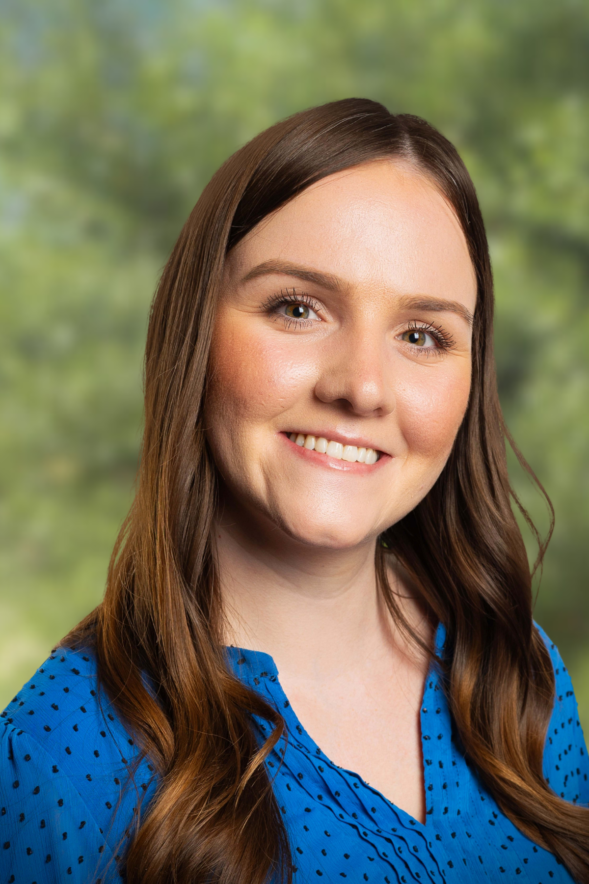 Smiling young woman with brown hair and natural makeup.