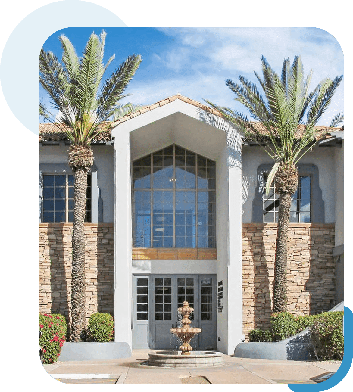 Group 28 Building entrance with palm trees and fountain.