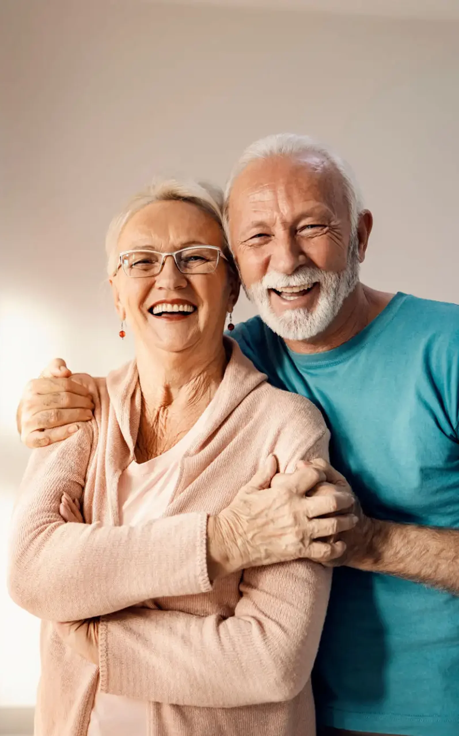 Happy elderly couple smiling and embracing warmly.